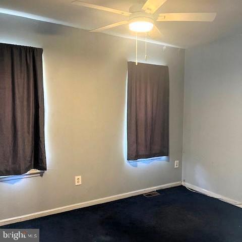 spare room featuring ceiling fan and carpet