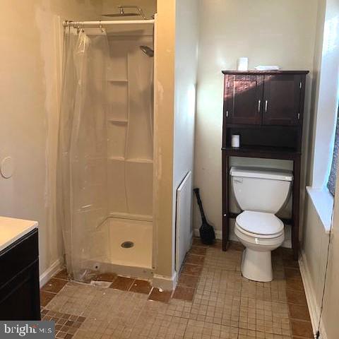 bathroom with toilet, vanity, and walk in shower