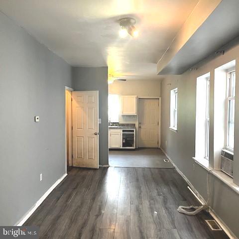 unfurnished living room featuring wine cooler, plenty of natural light, cooling unit, and dark hardwood / wood-style floors