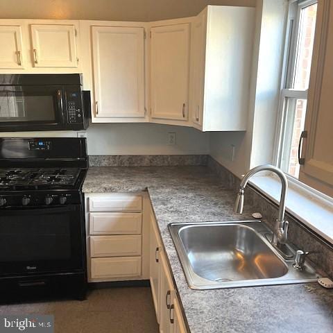 kitchen featuring sink, white cabinets, and black appliances