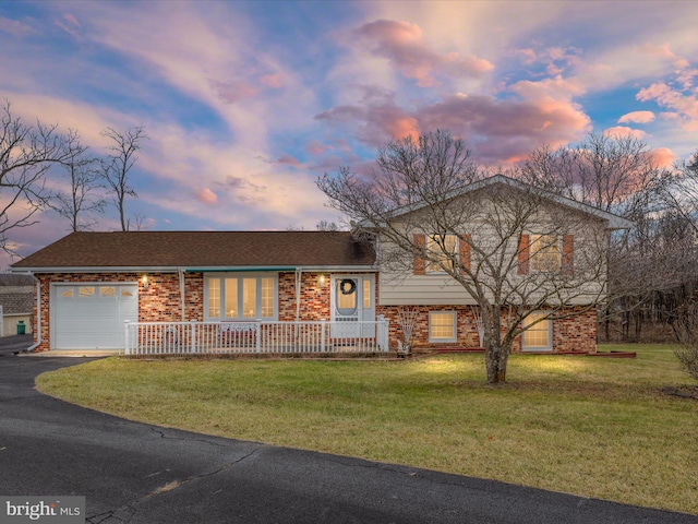 tri-level home with a garage and a yard