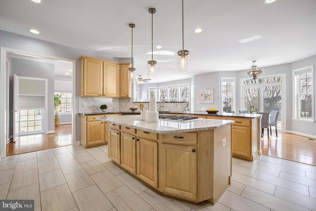 kitchen with kitchen peninsula, a kitchen island, and pendant lighting