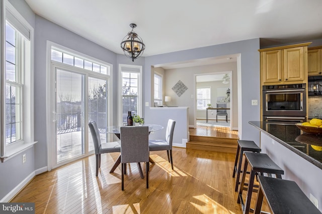 dining space with light hardwood / wood-style flooring and a notable chandelier