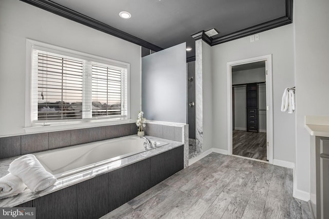 bathroom with hardwood / wood-style flooring, separate shower and tub, and ornamental molding