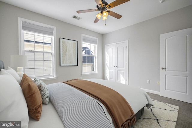 carpeted bedroom with ceiling fan and a closet