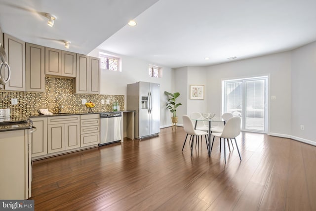 kitchen featuring decorative backsplash, a healthy amount of sunlight, sink, and stainless steel appliances