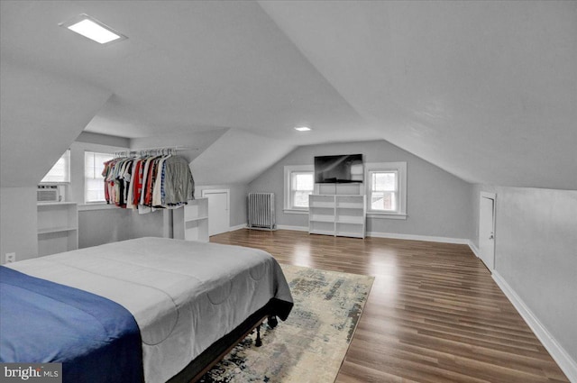 bedroom featuring hardwood / wood-style flooring, vaulted ceiling, and cooling unit