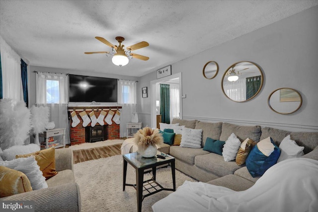 living room featuring hardwood / wood-style flooring, ceiling fan, plenty of natural light, and a textured ceiling