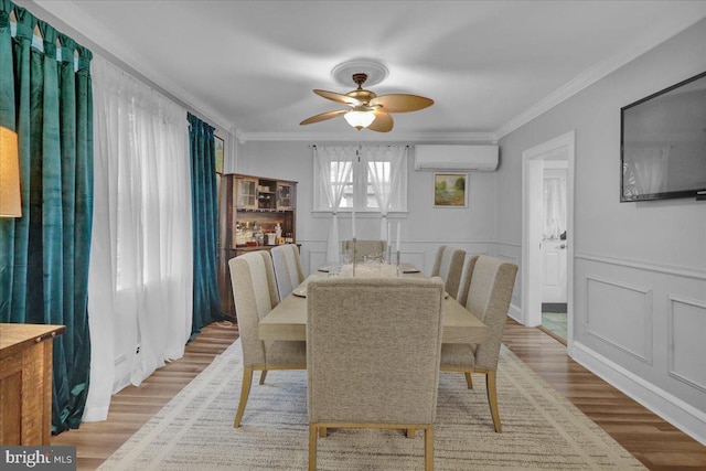 dining space featuring ornamental molding, a wall mounted AC, and light hardwood / wood-style flooring