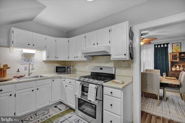 kitchen featuring white cabinetry, sink, vaulted ceiling, and appliances with stainless steel finishes