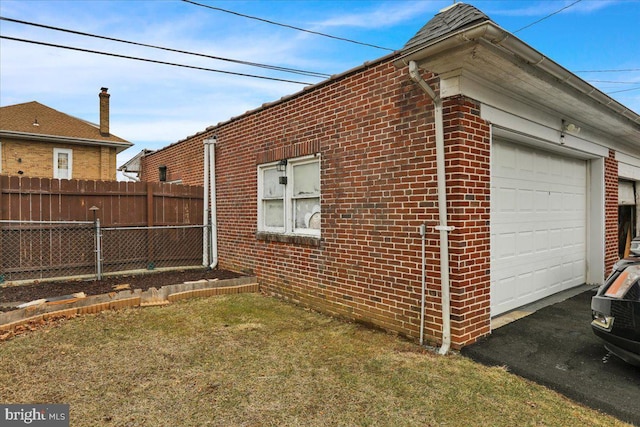 view of side of home with a garage and a lawn