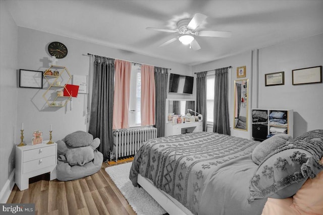 bedroom featuring radiator, ceiling fan, and light wood-type flooring