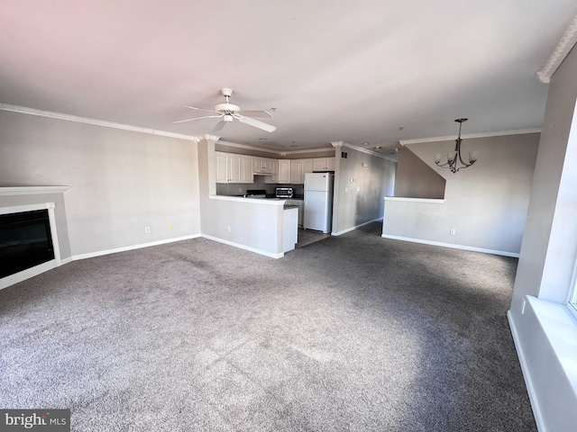 unfurnished living room with dark colored carpet, ceiling fan with notable chandelier, and crown molding