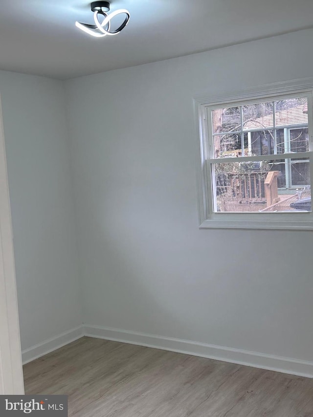 unfurnished room with wood-type flooring