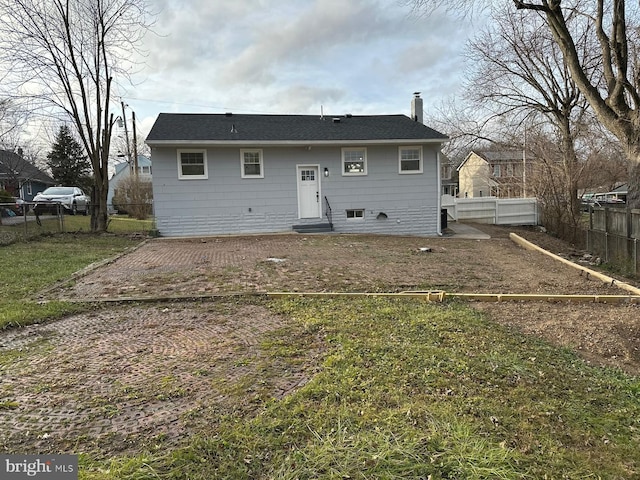 rear view of house featuring a yard