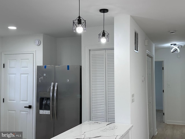 kitchen with pendant lighting, stainless steel fridge with ice dispenser, and hardwood / wood-style floors