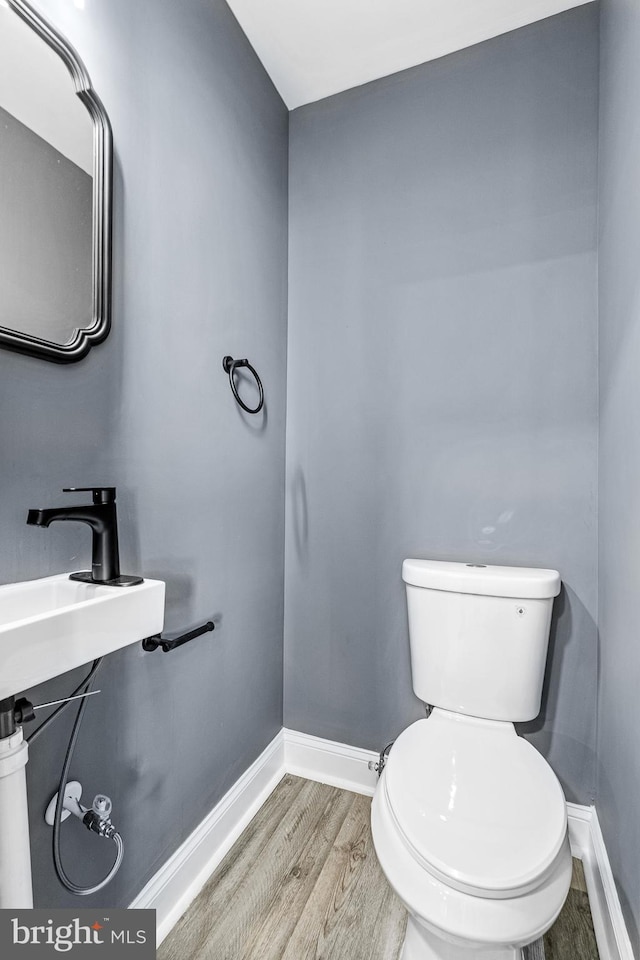 bathroom with sink, toilet, and hardwood / wood-style flooring