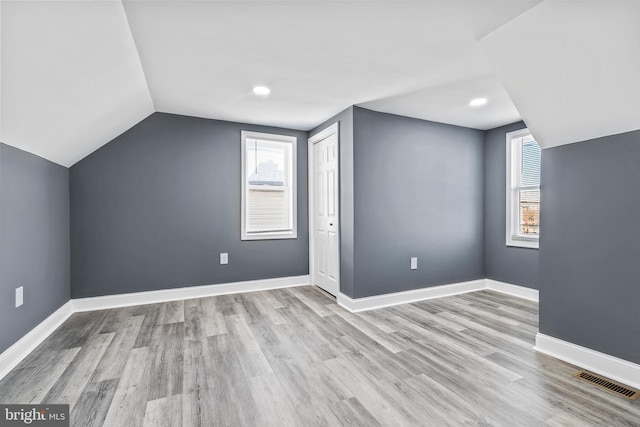 bonus room featuring a healthy amount of sunlight, vaulted ceiling, and light hardwood / wood-style flooring