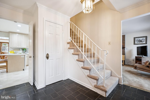 staircase featuring a notable chandelier, carpet, and ornamental molding