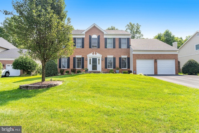 colonial house with a front lawn and a garage