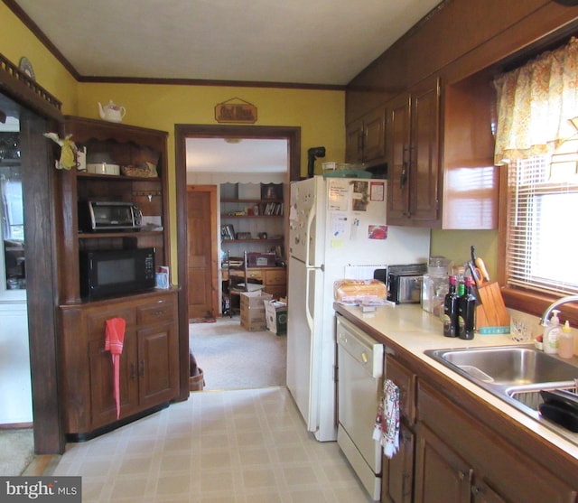 kitchen featuring crown molding, white appliances, and sink