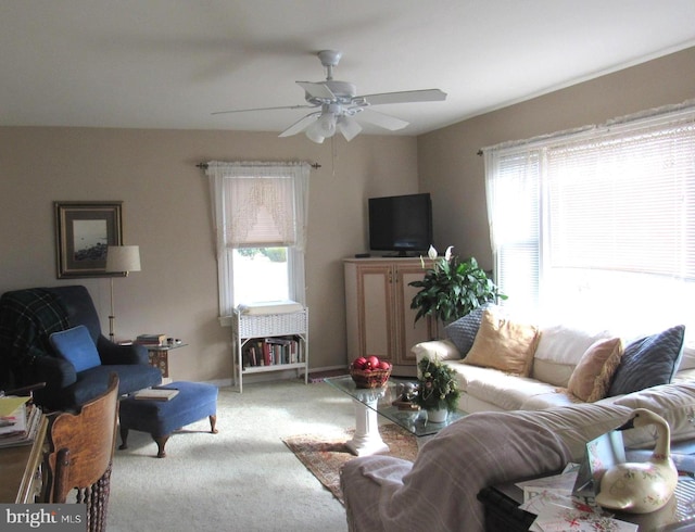 carpeted living room with ceiling fan