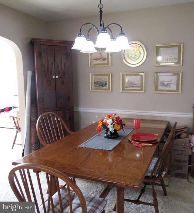 dining space featuring light colored carpet and a chandelier