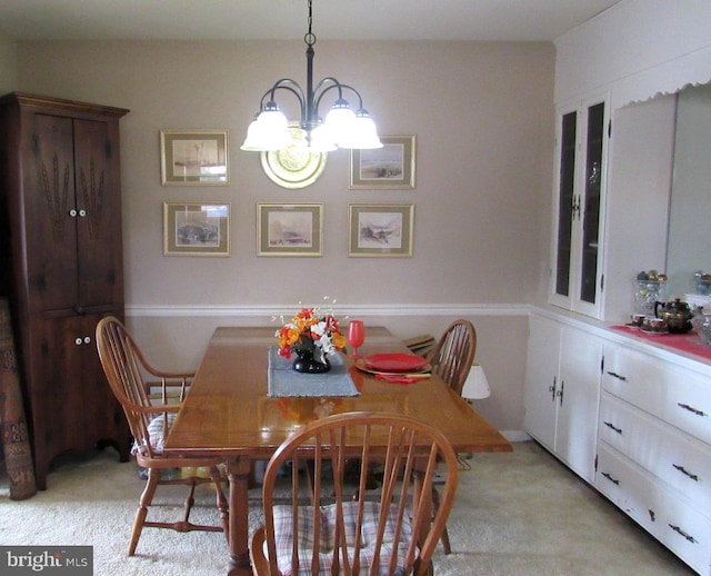 dining space featuring light colored carpet and an inviting chandelier