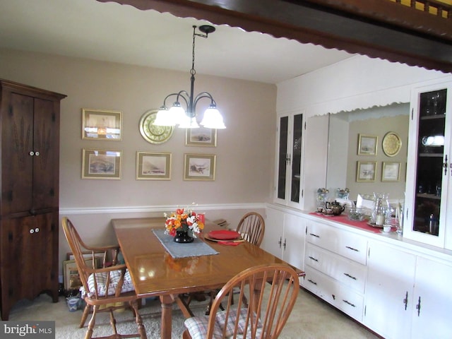 dining room with light colored carpet and a chandelier