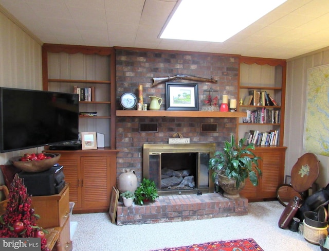 living room featuring built in shelves, light carpet, and a brick fireplace