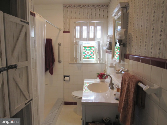 bathroom with vanity, toilet, tile walls, and curtained shower