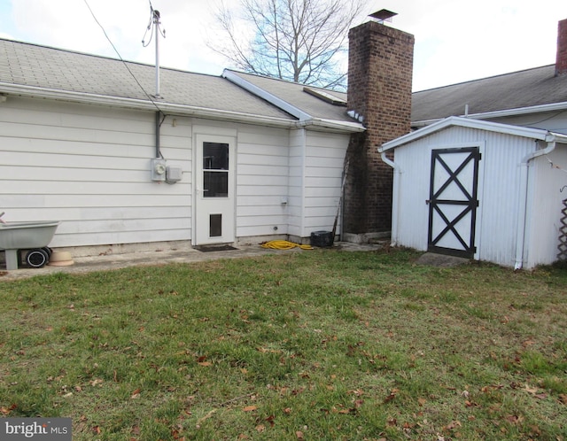 back of property featuring a storage shed and a lawn