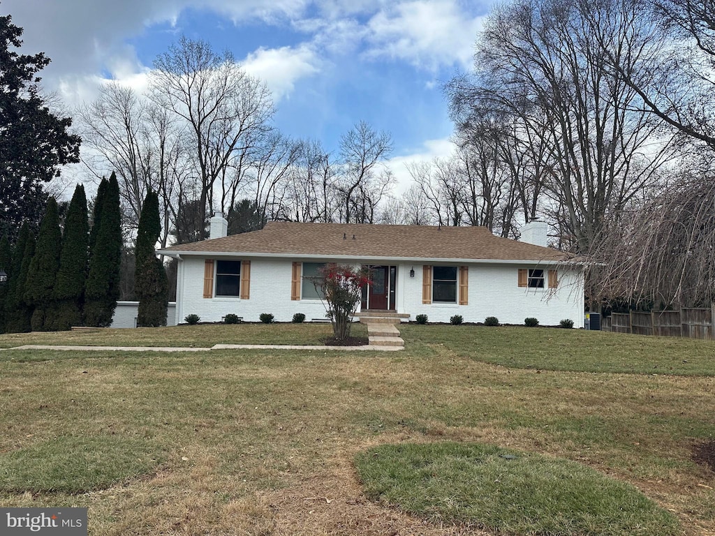 ranch-style house with central AC and a front lawn