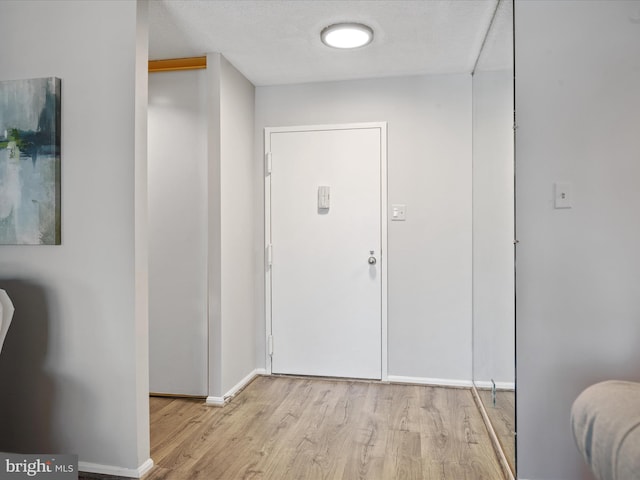 interior space with a textured ceiling and light hardwood / wood-style flooring