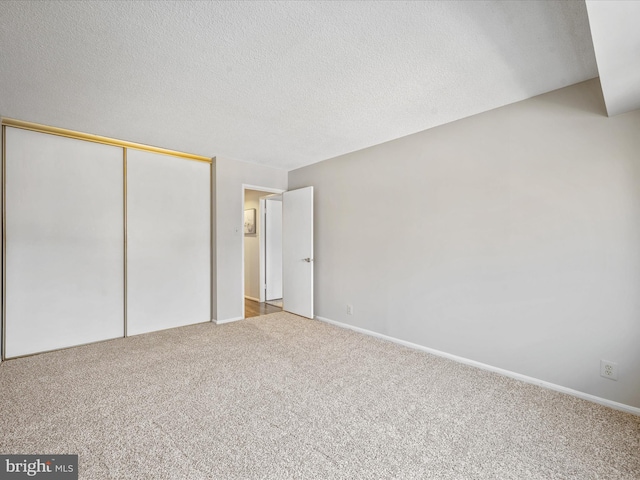 unfurnished bedroom with a textured ceiling, a closet, and carpet floors