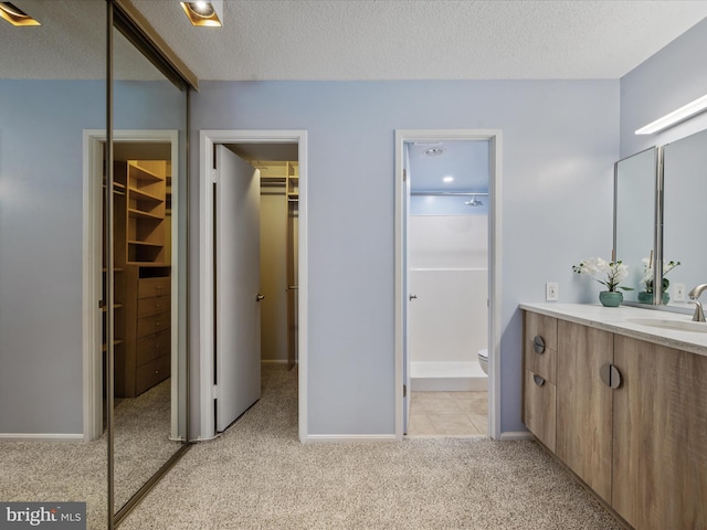 bathroom featuring toilet, vanity, and a textured ceiling