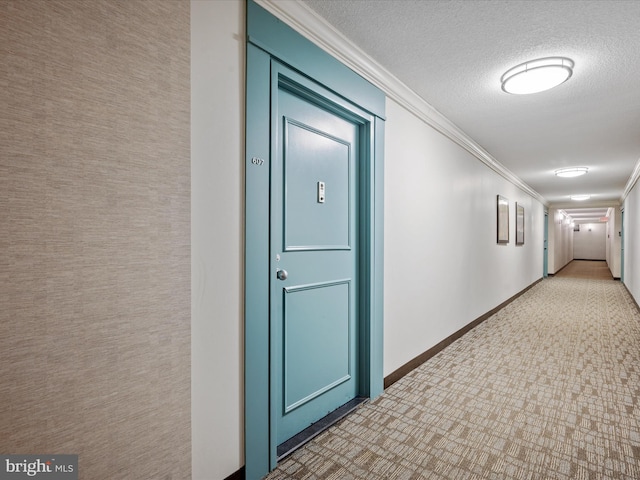 hall featuring a textured ceiling and crown molding