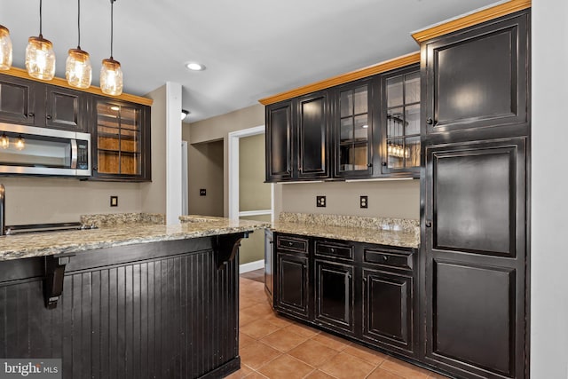 kitchen with light stone countertops, light tile patterned floors, and hanging light fixtures