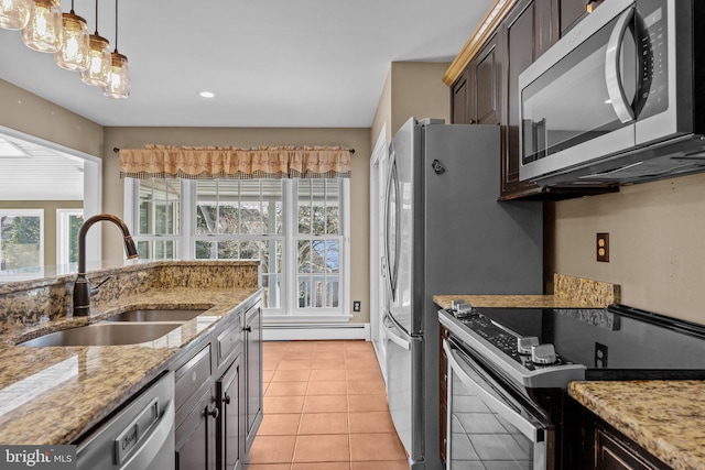 kitchen with sink, light stone countertops, light tile patterned floors, dark brown cabinetry, and stainless steel appliances