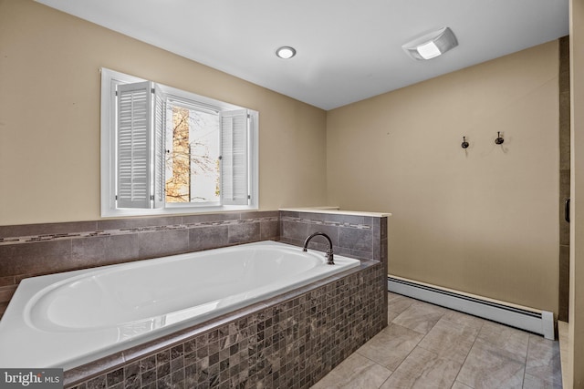 bathroom featuring tile patterned flooring, a baseboard heating unit, and tiled tub