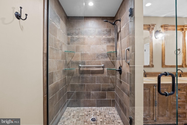 bathroom with a shower with door and sink