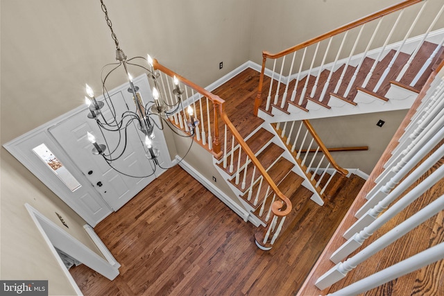 stairway with a chandelier and wood-type flooring