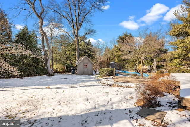 yard covered in snow featuring a shed