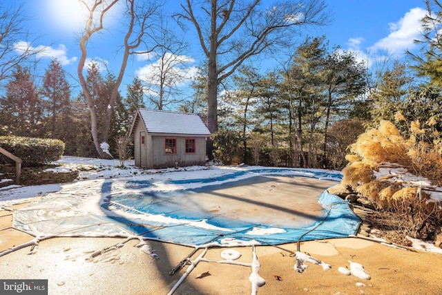 snow covered pool featuring a shed