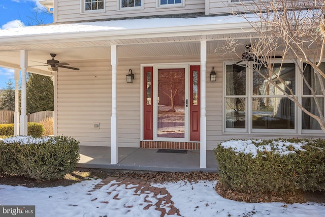 snow covered property entrance with ceiling fan