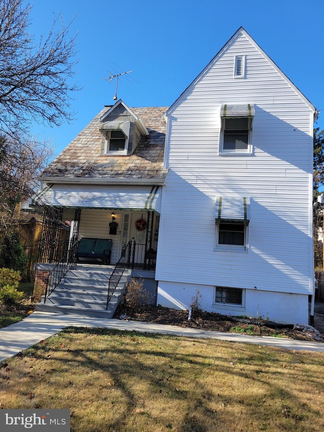 view of front of house with a porch and a front lawn