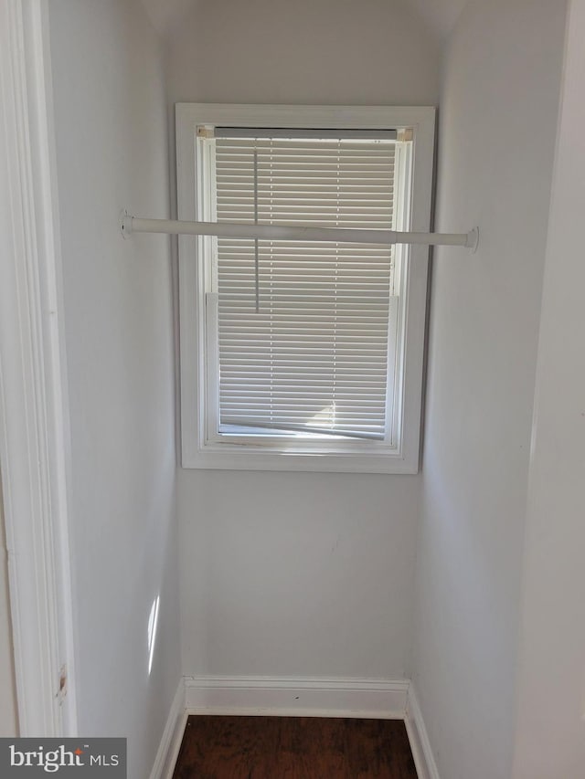 empty room with dark wood finished floors and baseboards