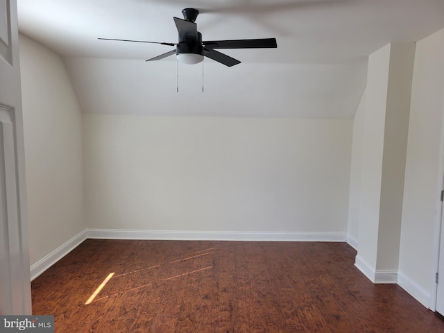 additional living space with vaulted ceiling, dark wood finished floors, a ceiling fan, and baseboards