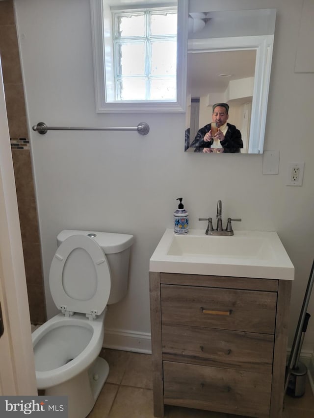 bathroom with baseboards, vanity, toilet, and tile patterned floors