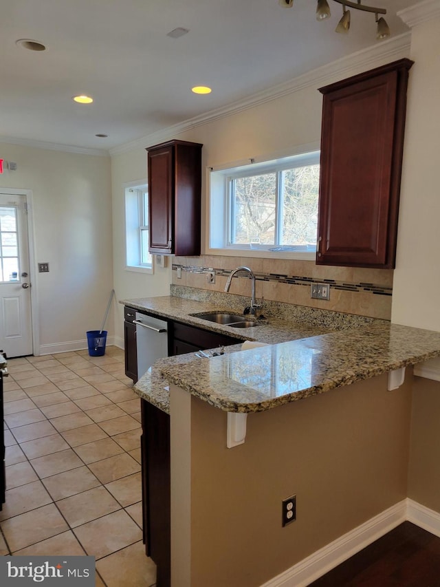 kitchen with light stone counters, stainless steel dishwasher, ornamental molding, a sink, and a peninsula